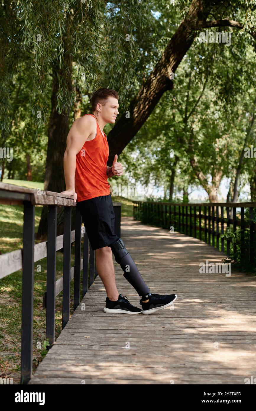 uomo che si allena all'aperto, mostra forza in mezzo alla natura e mostra il pollice in su Foto Stock