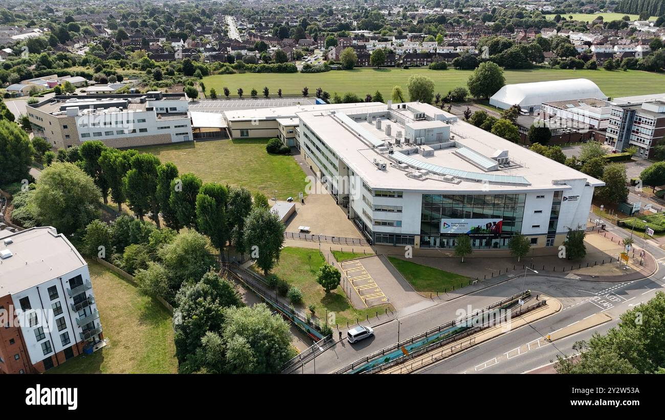 Vista aerea di un moderno istituto educativo con vegetazione circostante e paesaggio urbano. Foto Stock