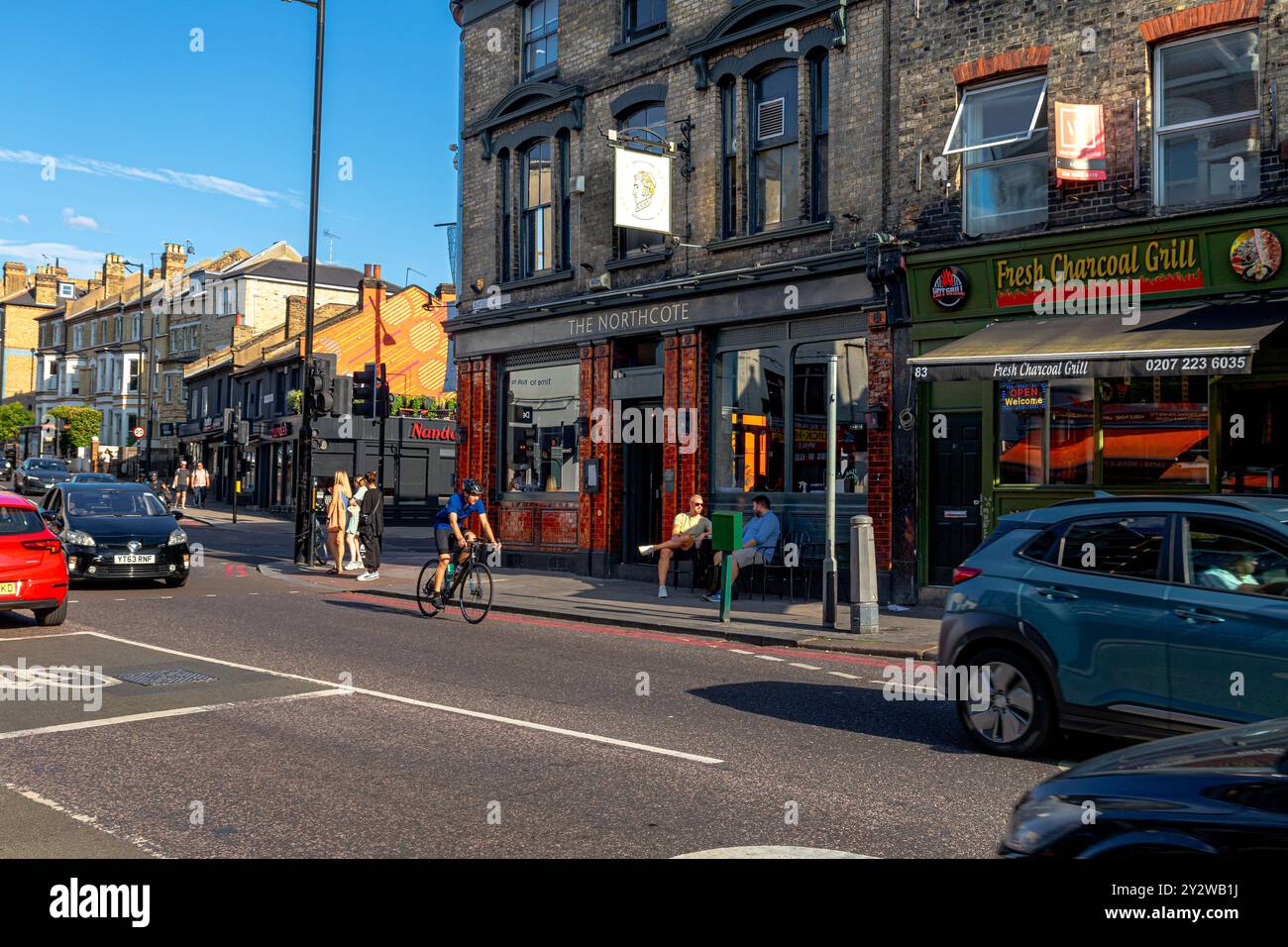 Due persone sedute fuori dal Northcote, un pub in Clapham Junction all'angolo tra Battersea Rise e Northcote Road, London SW11 Foto Stock