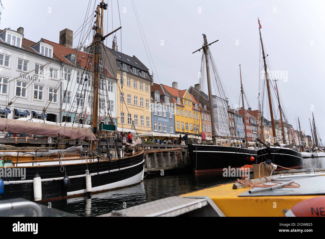 Edifici colorati sul lungomare e barche a vela storiche a Nyhavn, Copenhagen. Iconico porto danese, perfetto per viaggi e fotografie di architettura. Foto Stock