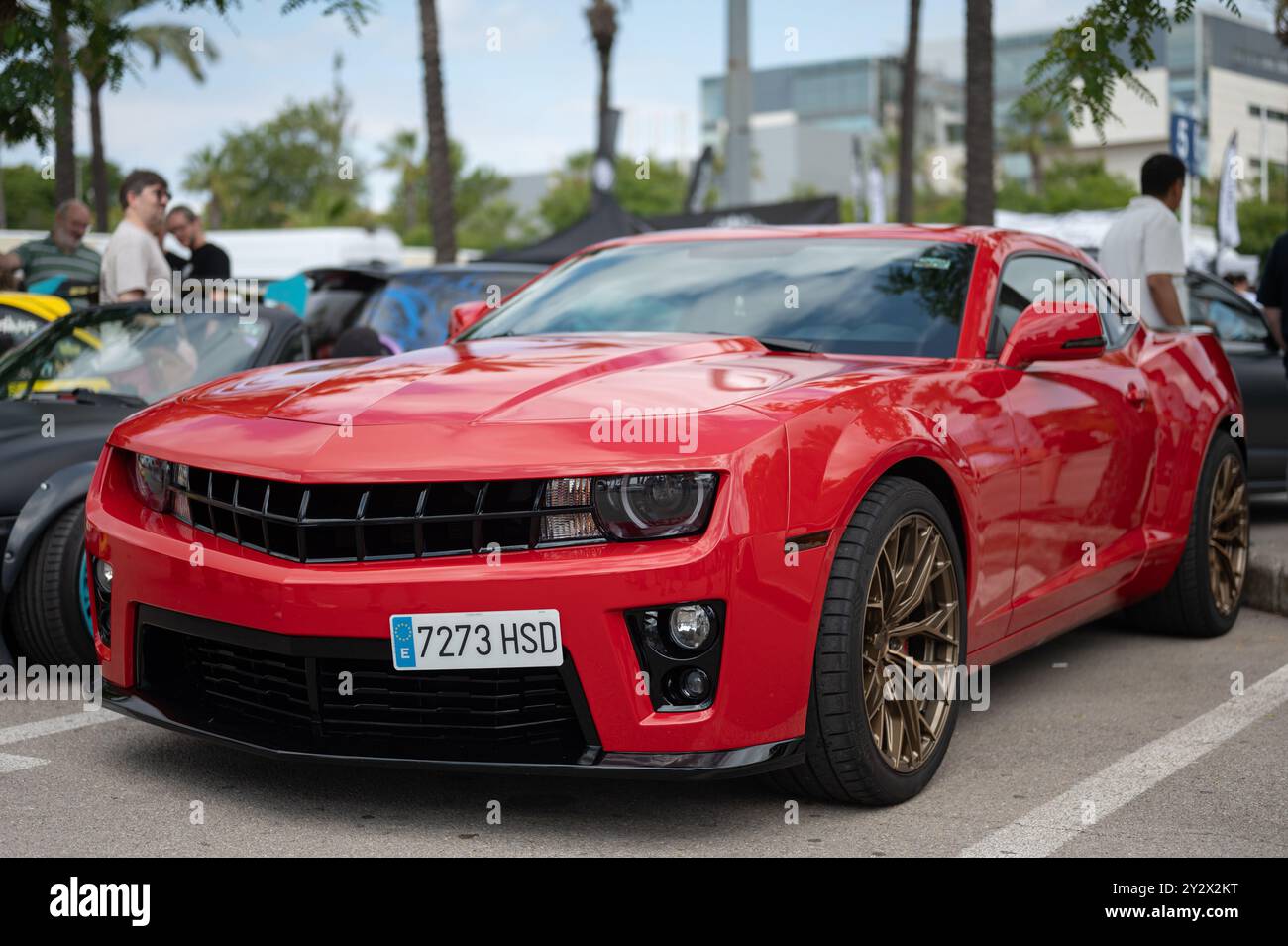 Dettaglio di una spettacolare auto sportiva americana, Chevrolet Camaro di quinta generazione, rossa con cerchi dorati in una riunione di auto Foto Stock