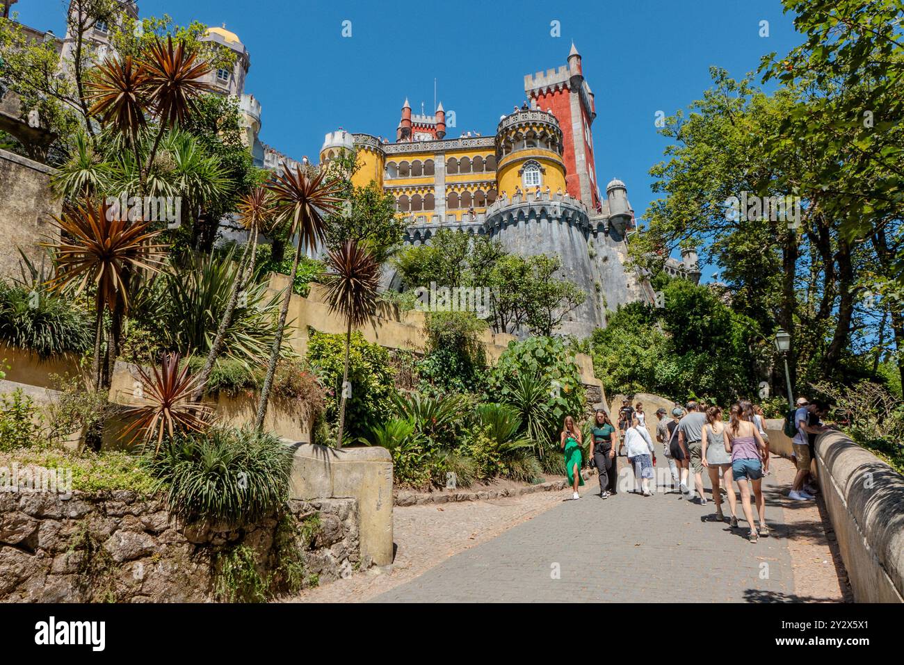 I turisti che camminano sulla rampa per il Palácio da pena, un palazzo romanticista con uno stile eclettico che spazia dall'arabo al gotico e neo-medievale costruito sotto l'ordine di re Ferdinando II nel XIX secolo. Foto Stock