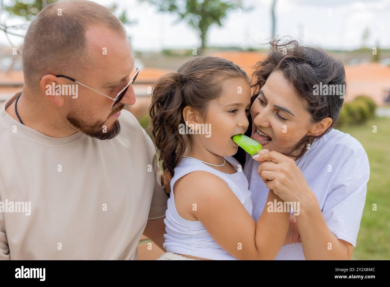 Una famiglia felice si rilassa nel parco e mangia un gelato. Foto di alta qualità Foto Stock