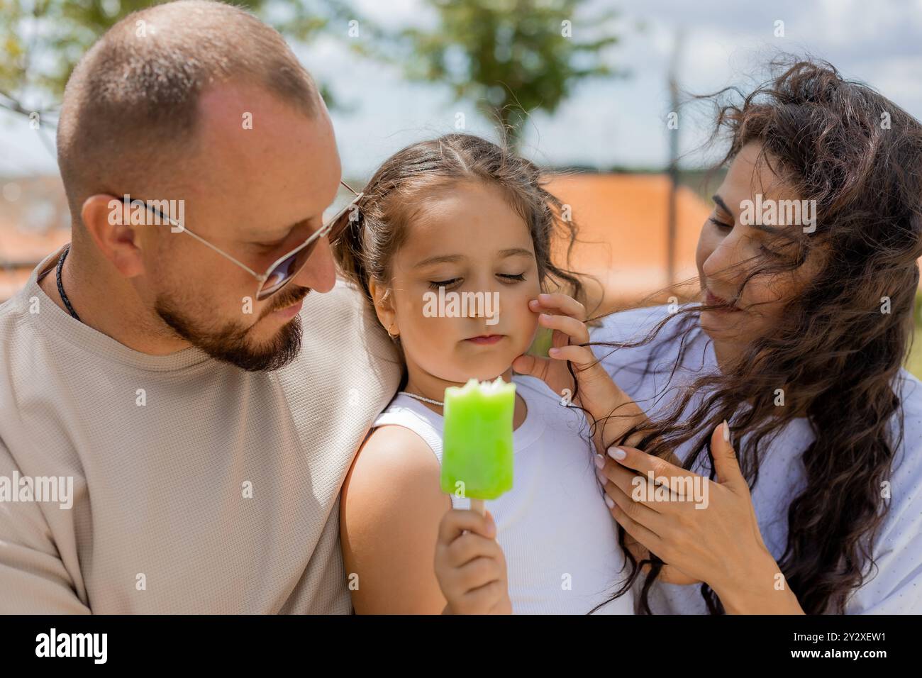 Una famiglia felice si rilassa nel parco e mangia un gelato. Foto di alta qualità Foto Stock