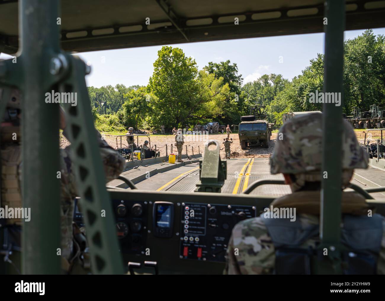 I soldati con la 341st Multi-Role Bridging Company costruiscono un ponte a nastro parziale per trasportare veicoli pesanti attraverso il fiume Arkansas al Fort Chaffee Joint Maneuver Training Center, 19 luglio 2024. La società di ingegneri della U.S. Army Reserve si stava allenando in cross con i nuovi membri della società durante la "fase di camminata" della loro formazione. La formazione trasversale garantisce che ogni membro dell'equipaggio del ponte comprenda ogni aspetto della costruzione del ponte e conosca tutti i problemi che potrebbero insorgere e come risolverli. Per un'azienda di ponte, che ha un ambiente difficile come t Foto Stock