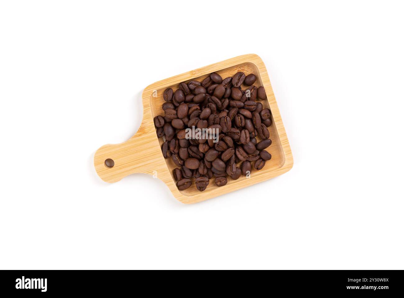 Chicchi di caffè tostati scuri in un piccolo vassoio di legno isolato su bianco Foto Stock