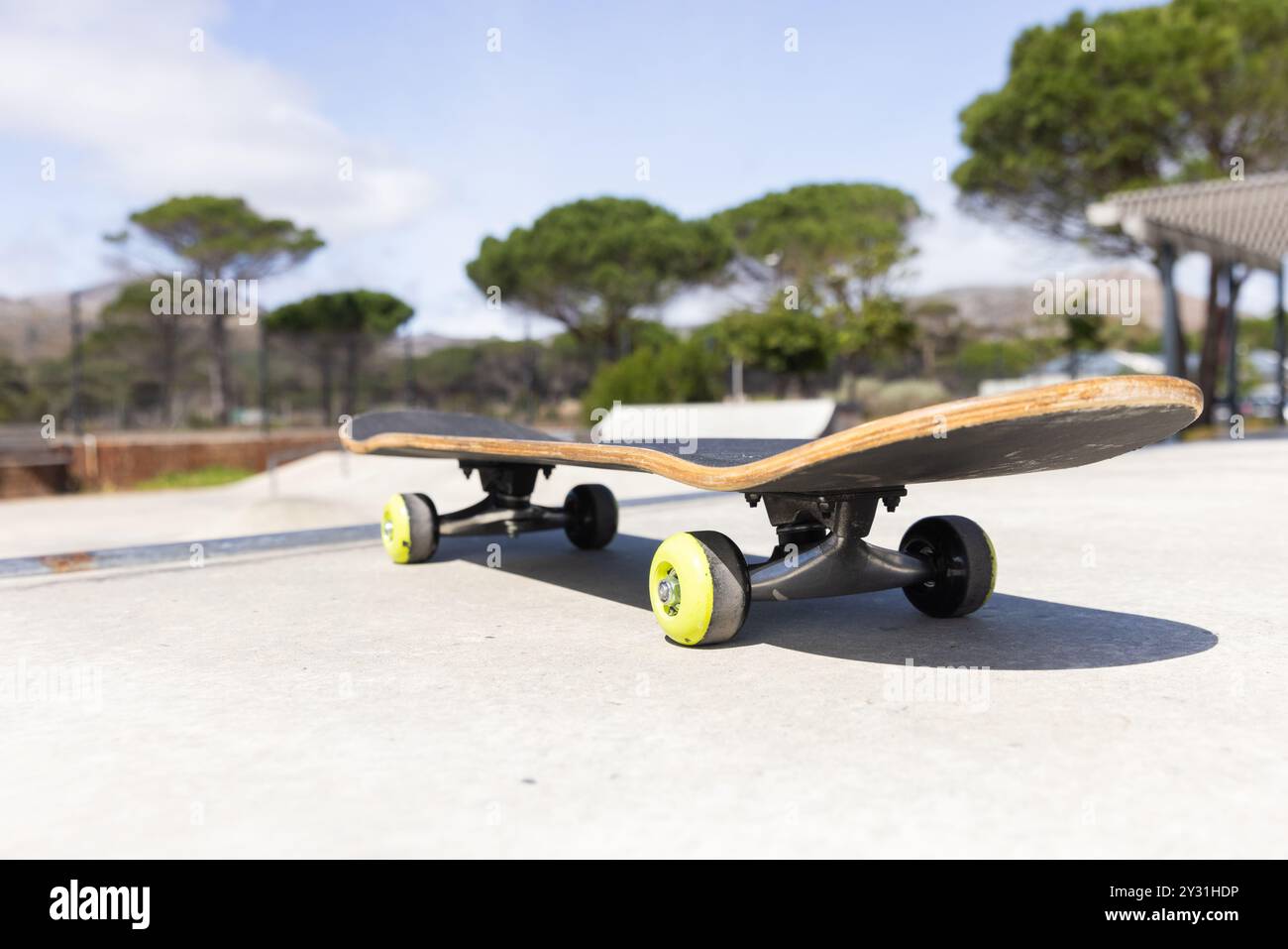 Skateboard appoggiato su una superficie in cemento presso lo skate Park all'aperto nelle giornate di sole Foto Stock