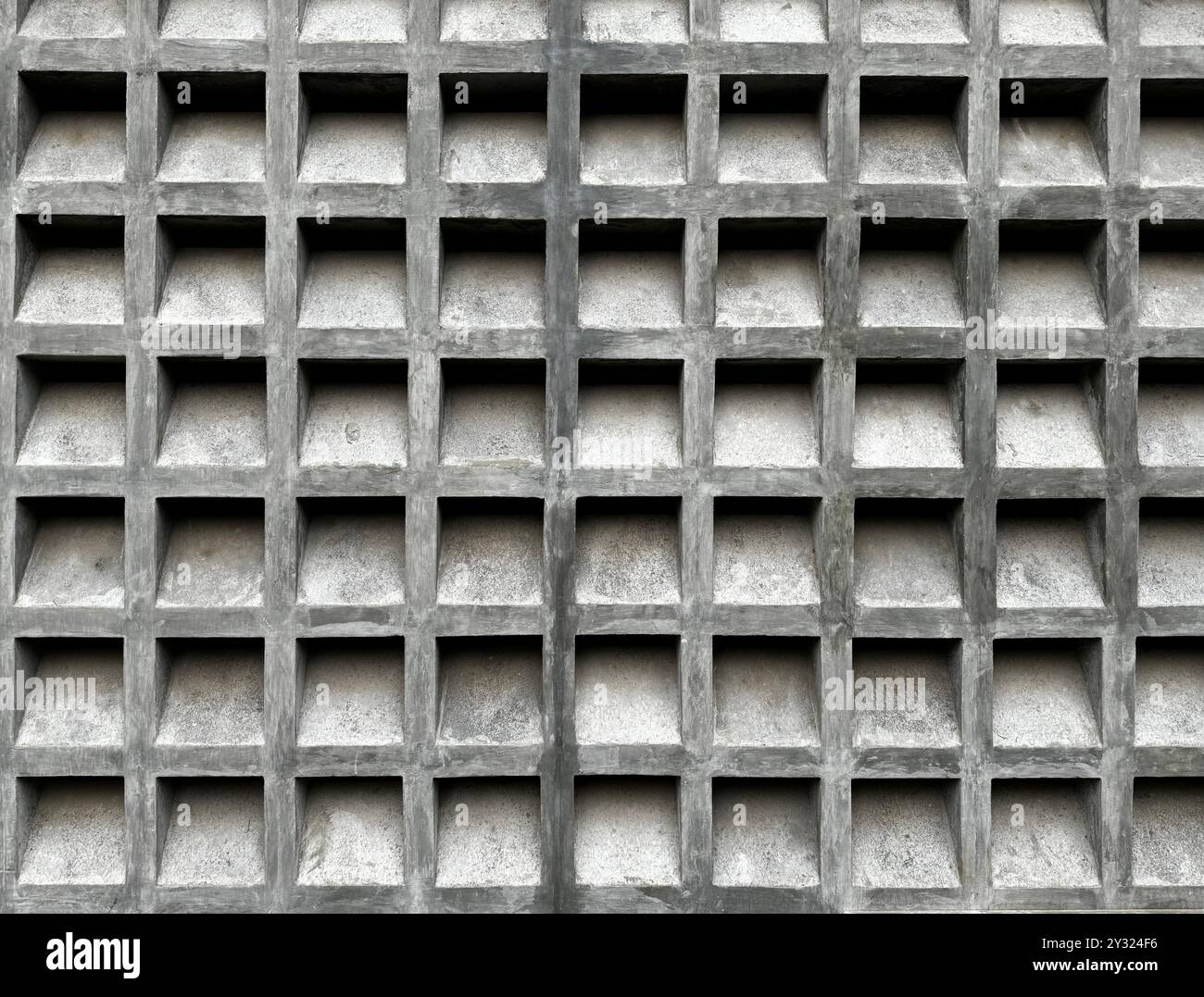 In calcestruzzo bianco, blocco o parete a brezza, con un motivo quadrato di modanatura. Questo blocco di brezza viene spesso applicato alla facciata dell'edificio. Foto Stock