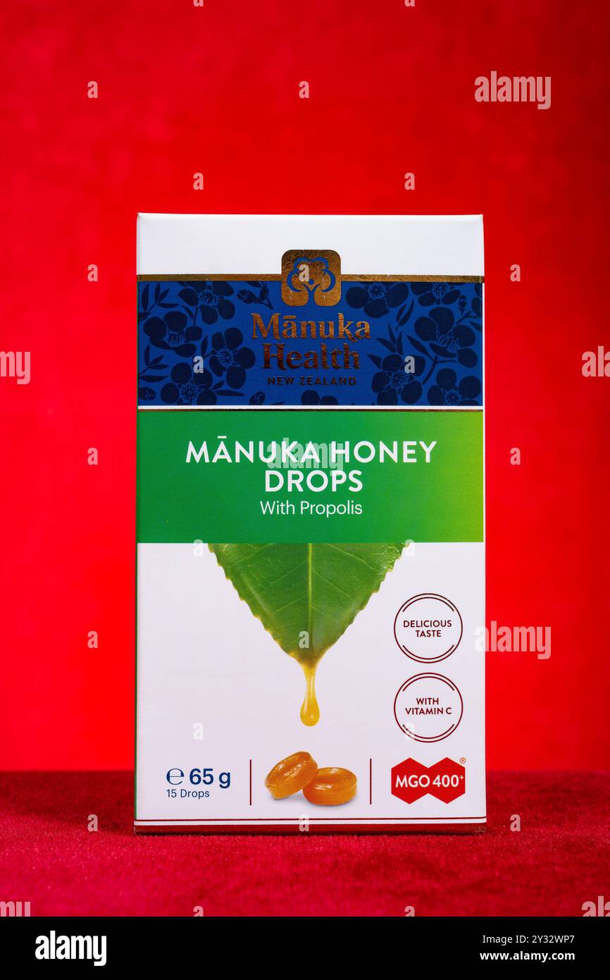 Zhongshan Cina-giugno 13 2024:scatola di Manuka salute miele gocce con propoli su sfondo rosso. Foto Stock