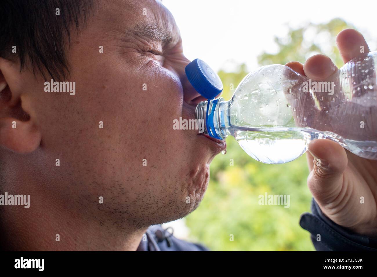 Baviera, Germania - 12 settembre 2024: Problema simbolico dell'immagine quando si beve con un tappo fissato saldamente alla bottiglia in PET. Questo cambiamento di design, introdotto per ridurre gli sprechi di plastica, può portare a difficoltà quando si beve *** Symbolbild Problem beim Trinken mit einem Tethered Cap, einem fest an der PET-Flasche befestigten Deckel. Diese Designänderung, Die zur Reduzierung von Plastikmüll eingeführt wurde, kann zu Schwierigkeiten beim Trinken führen Foto Stock