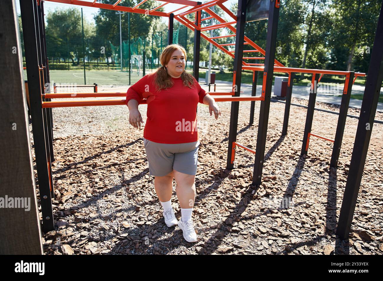 Una donna gioiosa si esercita all'aperto in un vivace parco. Foto Stock