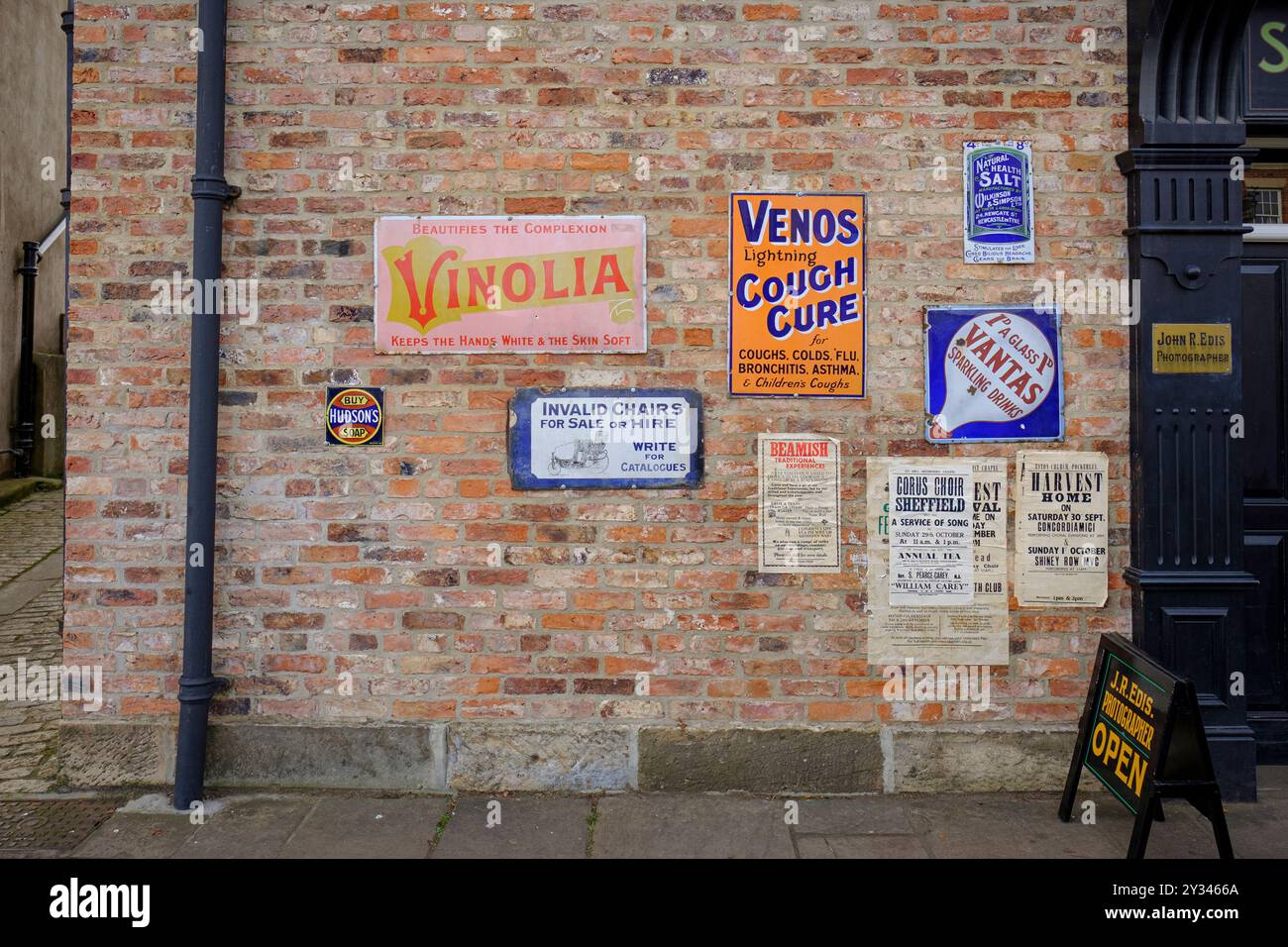 Avvisi pubblicitari vintage annunci pubblicitari su un muro esterno del museo all'aperto Beamish, County Durham, Inghilterra, Regno Unito. Foto Stock