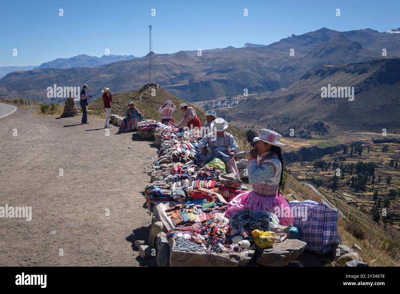 Una banchina di mercato lungo la strada nell'Altiplano andino, in Perù, che vende tessuti, sciarpe, guanti e cappelli. I proprietari delle bancarelle sono donne adulte nella tradizione peruviana Foto Stock