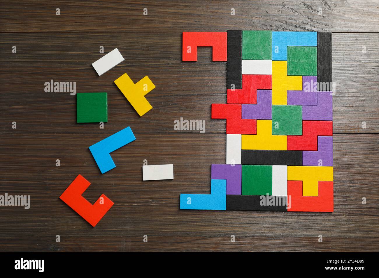 Puzzle colorati su un tavolo di legno, vista dall'alto Foto Stock