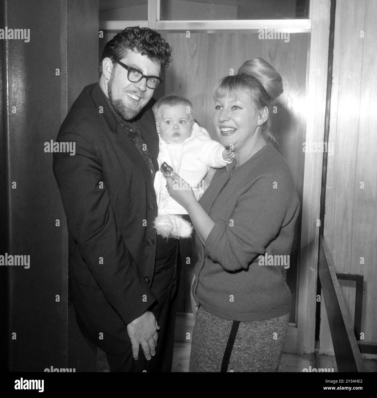 Foto del file datata 15/11/1964 di Rolf Harris con sua moglie Alwen e la figlia di sette mesi Bindi all'aeroporto di Londra. La moglie di Harris, Alwen Hughes, è morta all'età di 92 anni, poco più di un anno dopo che l'intrattenitore disonorato morì a casa a Bray, Berkshire. La scultrice e gioielliere gallese sposò Harris nel 1958 e rimase con suo marito dopo essere stato condannato per aggressione indecente alle giovani ragazze. Data di pubblicazione: Giovedì 12 settembre 2024. Foto Stock