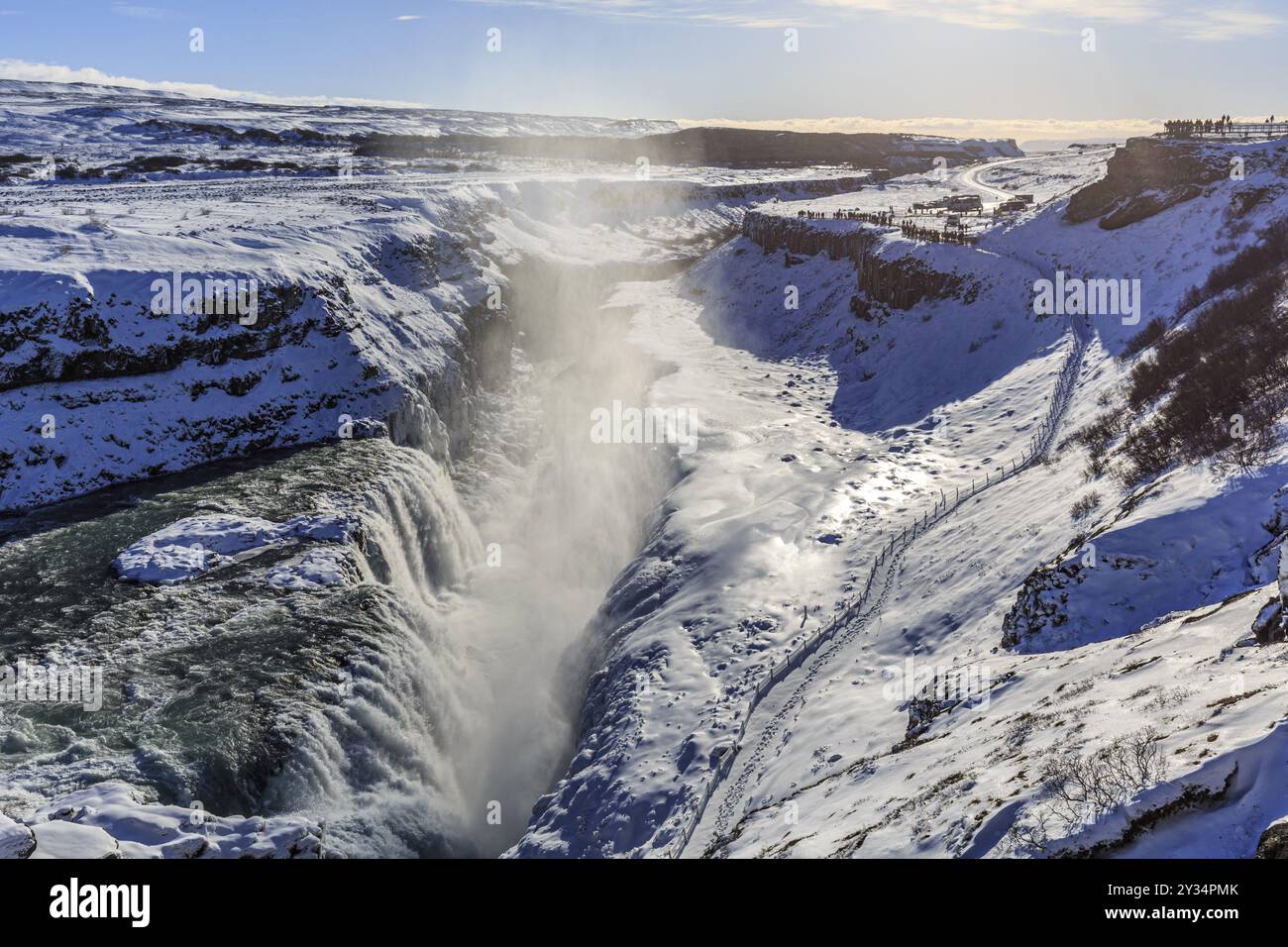 Grande cascata in una gola nella neve, inverno, sole, retroilluminazione, spruzzi, Gullfoss, Golden Circle, Islanda sud-occidentale, Islanda, Europa Foto Stock