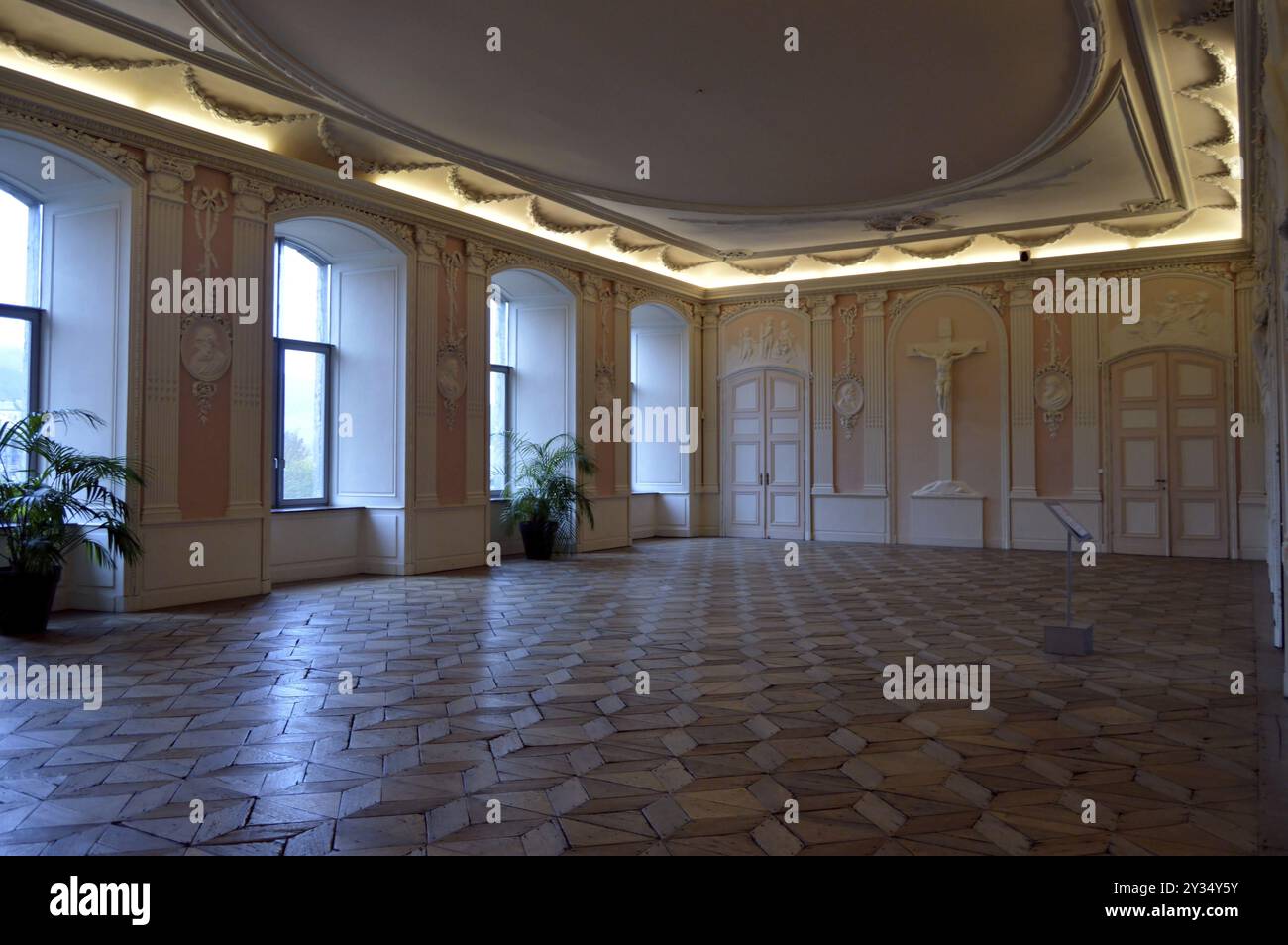 Antico refettorio dei monaci con una croce e un pavimento in rovere Foto Stock