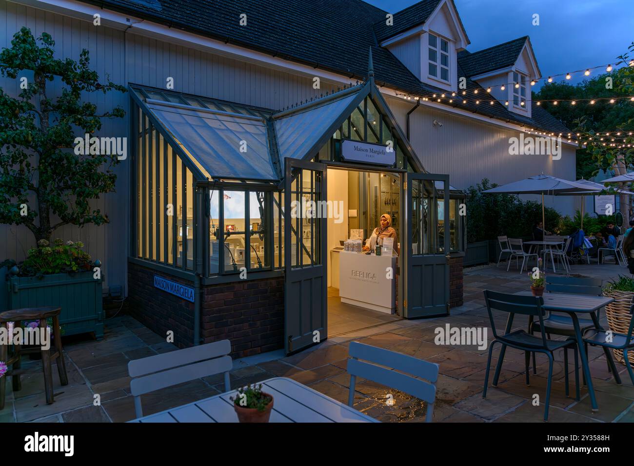 Una donna ansiosa che vende prodotti di bellezza è il negozio Maison Margiela al Bicester Village. Boutique di lusso in un villaggio in stile New England. Foto Stock