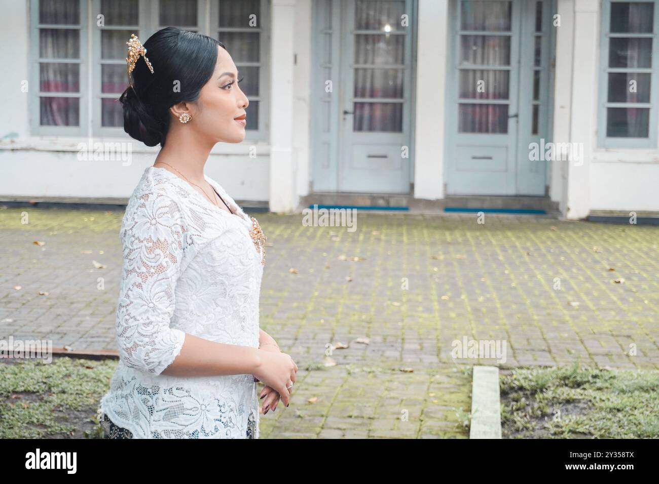 Una giovane donna indonesiana con una felice espressione di successo che indossa un kebaya bianco. Kartini's Day. Foto Stock