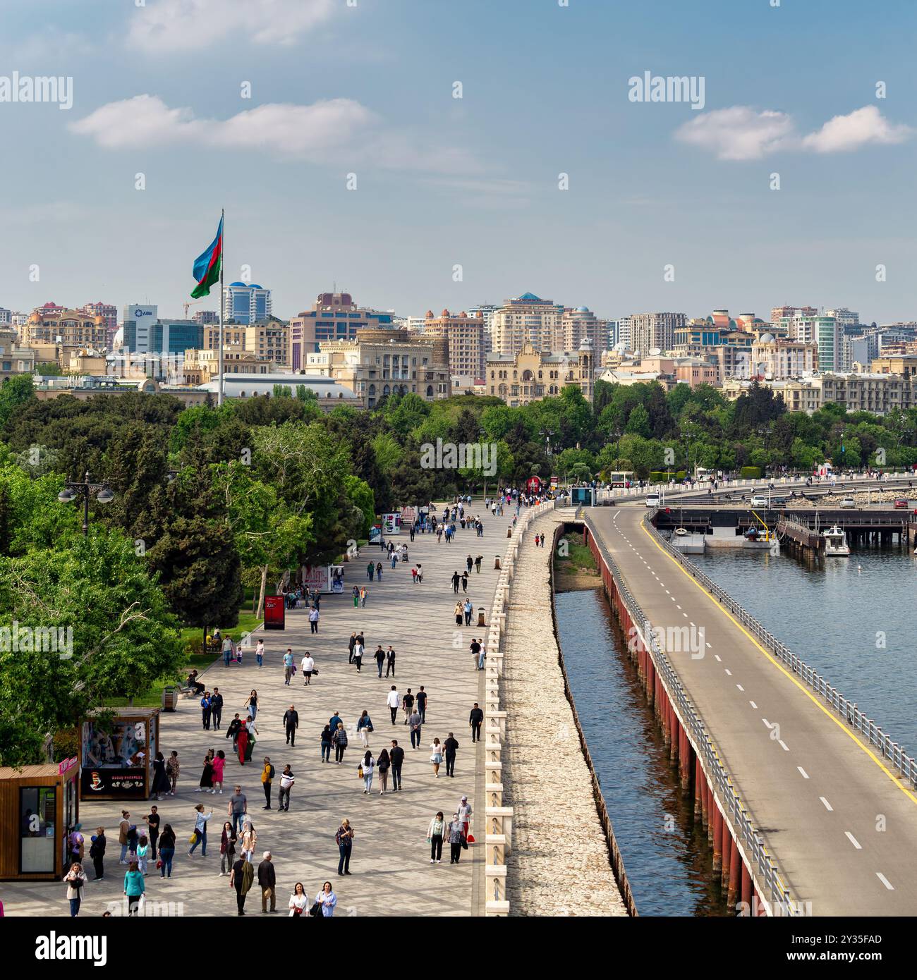 Baku, Azerbaigian - 4 maggio 2024: Le persone passeggiano lungo il viale Baku, godendosi l'aria fresca e le pittoresche vedute del lungomare e del vivace paesaggio urbano sotto un cielo limpido Foto Stock