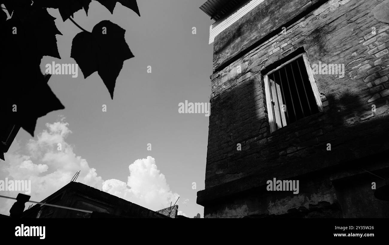 Immagine in bianco e nero di una vecchia casa. Gioco di luce sul vecchio muro. Howrah, Bengala Occidentale, India. Foto Stock