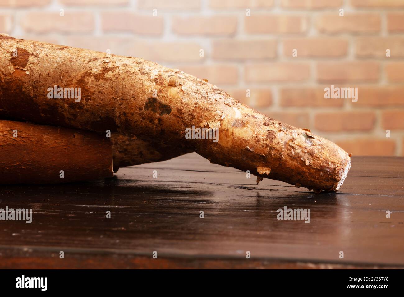 Tre radici di manioca su un tavolo di legno. Foto Stock