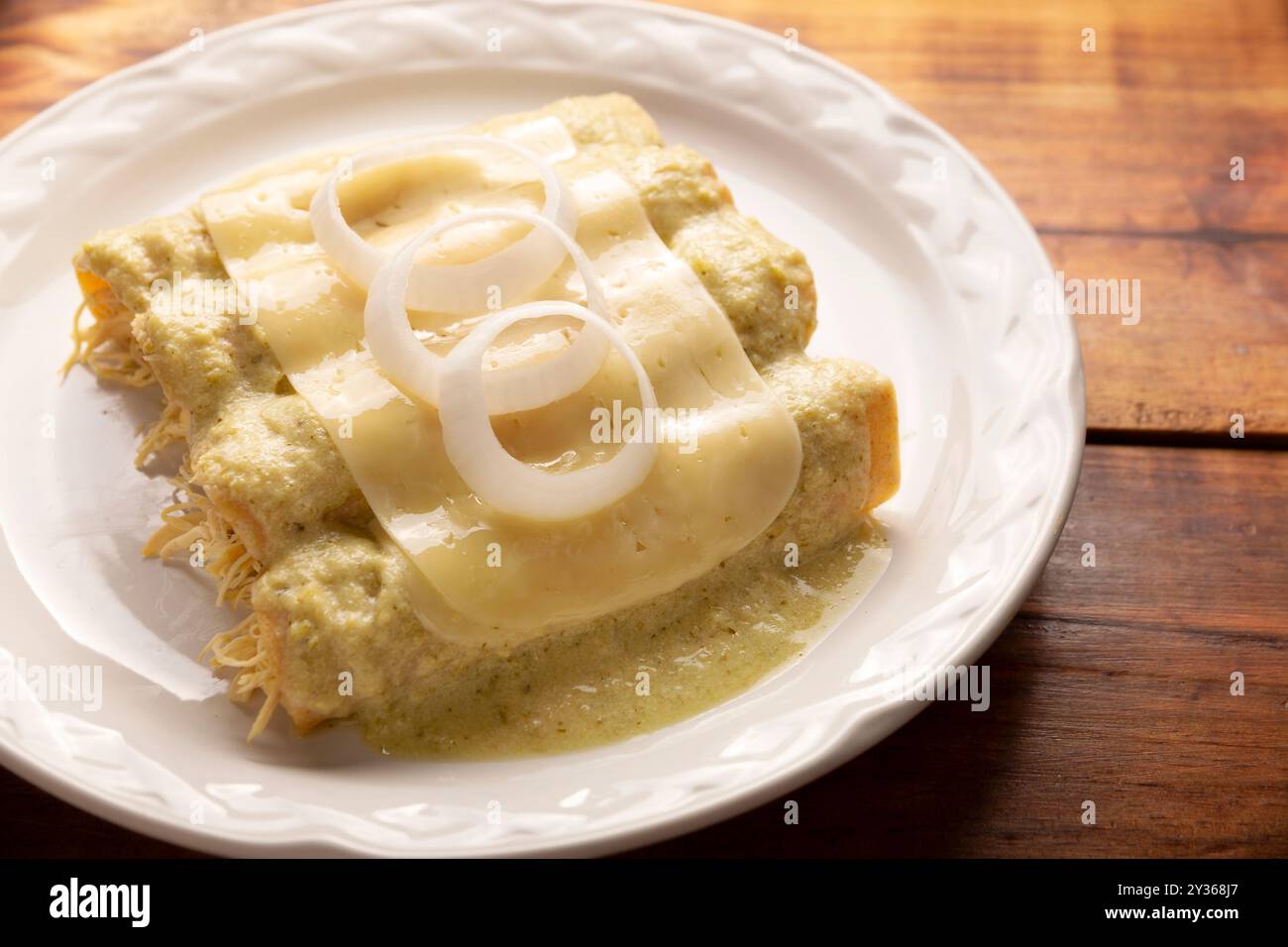 Cibo messicano. Enchiladas con salsa verde cremosa ripiena di carne di pollo grattugiata e ricoperta di formaggio fuso, in Messico si chiamano Swiss Enc Foto Stock