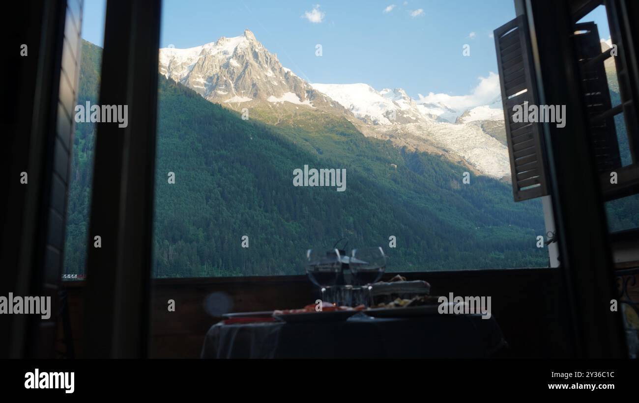 Vista panoramica del Monte bianco dalla finestra dell'appartamento con bicchieri da vino Foto Stock