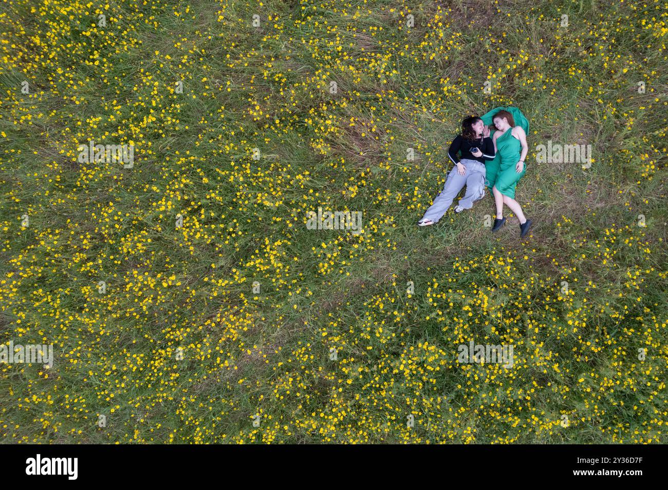 Vista dall'alto della donna che si stende su un prato in fiore. Primavera all'aperto Foto Stock