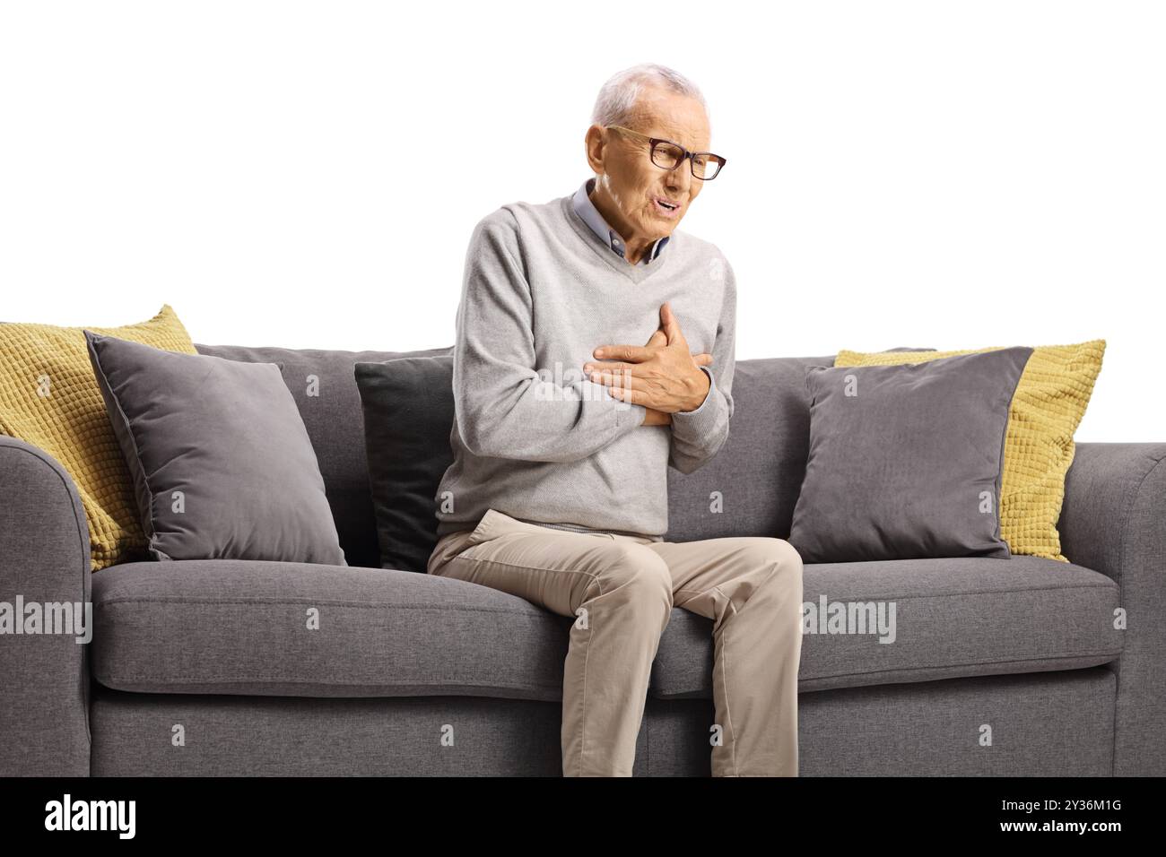 Uomo anziano con arresto cardiaco improvviso seduto su un divano isolato su sfondo bianco Foto Stock