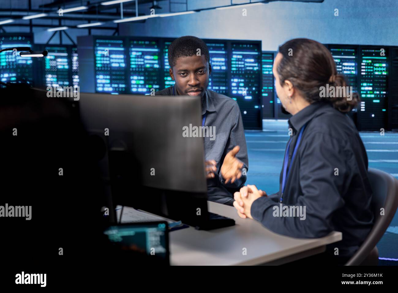 Gli amministratori di sistema riconfigurano la sala server per ottimizzarla in base alle esigenze di elaborazione dei dati dei clienti. Esperti IT che garantiscono il funzionamento efficiente delle apparecchiature dei data center, effettuando la manutenzione Foto Stock