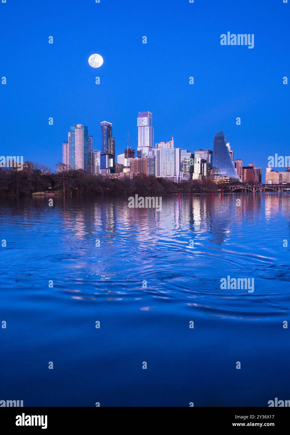 Edifici dello skyline di Austin, Texas, visti di notte con la luna piena e il fiume Lady Bird. Foto Stock