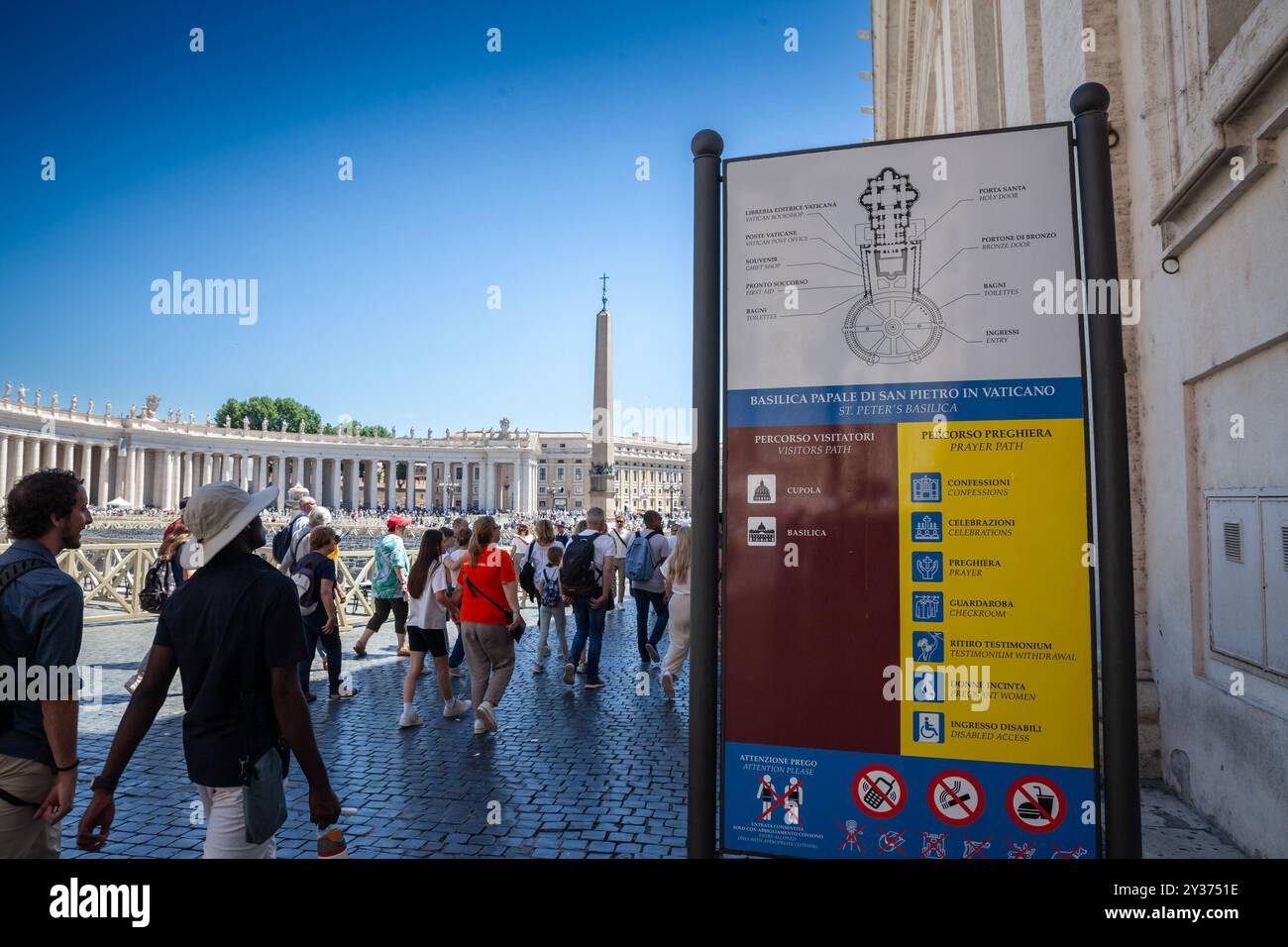 VATICANO - 15 GIUGNO 2024: I turisti passano accanto a un cartello che indica la mappa e le istruzioni per i visitatori in Piazza San Pietro, Vaticano, Foto Stock