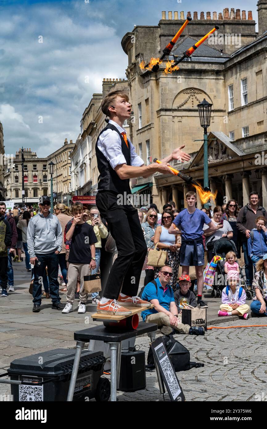 Bath; Inghilterra - 05-29-2024 : artista di strada, giocoliere e intrattenitore nella pittoresca città di Bath, Inghilterra. Giocoleria con bacchette fiammeggianti Foto Stock