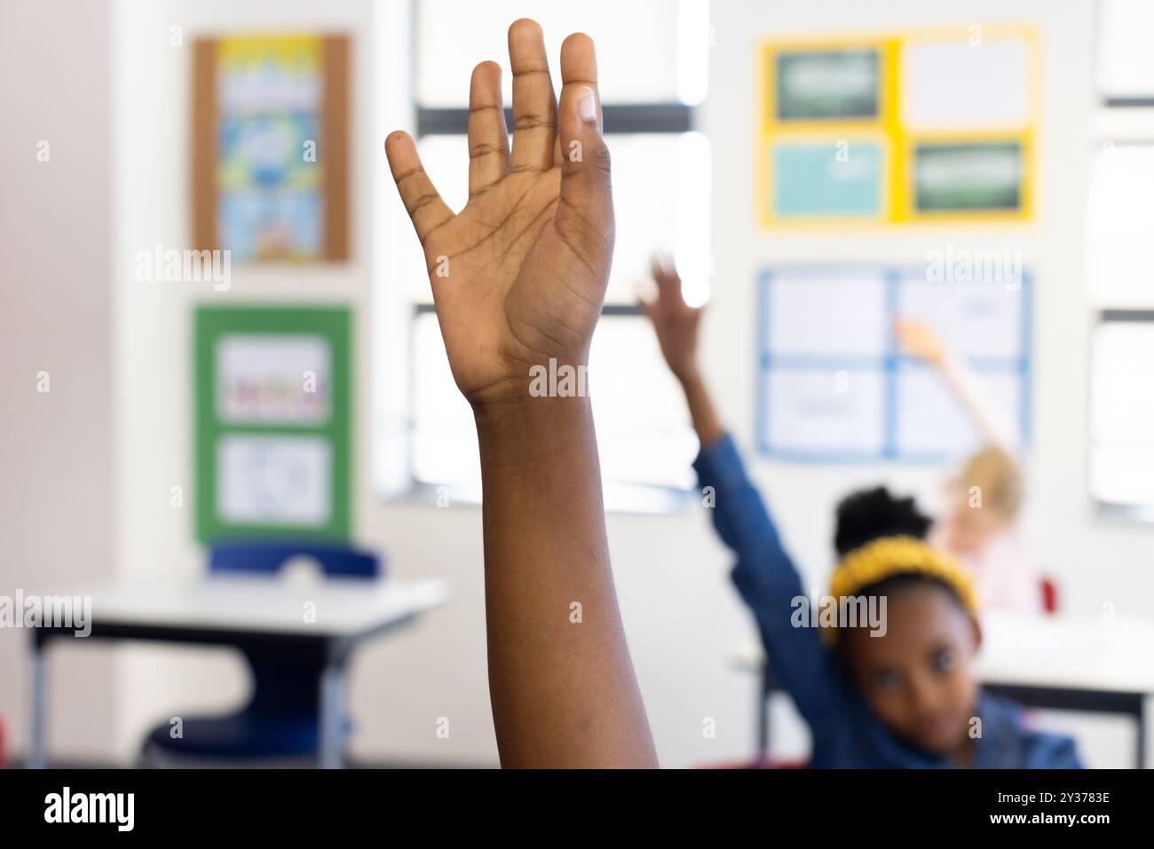 Alzando la mano in classe, ragazza afroamericana che partecipa attivamente alla lezione scolastica Foto Stock