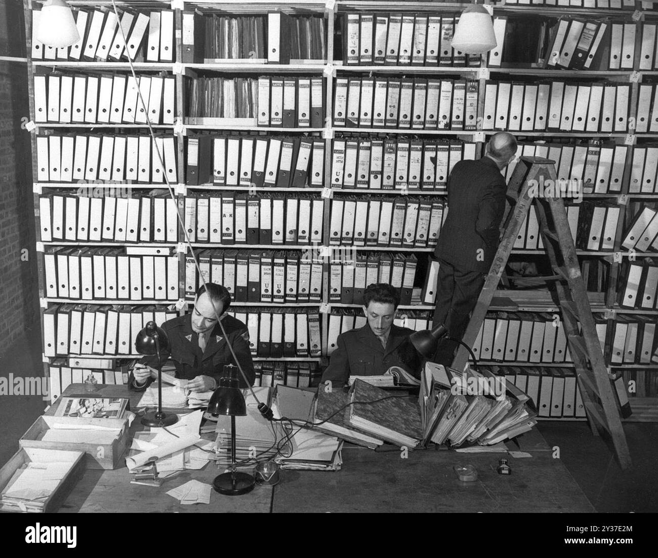 I ricercatori americani del Berlin Document Center esaminano i documenti tedeschi catturati che devono essere usati come prove nei processi per crimini di guerra. Il processo di Norimberga fu una serie di processi condotti dai principali leader militari e politici nazisti. Le prove si svolsero dal 1945 al 1949. Il primo fu il Tribunale militare internazionale che provò grandi nomi come Göring, Ribbentrop, Keitel, ecc.. Ci furono poi 12 processi contro gruppi di uomini tra cui medici, Einsatzgruppen e alto comando militare. Foto Stock