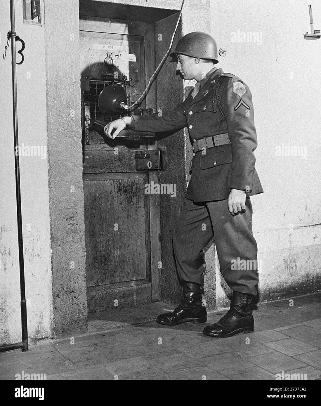 Un soldato americano a guardia della porta della cella di Rudolf Hess al processo di Norimberga. Il processo di Norimberga fu una serie di processi condotti dai principali leader militari e politici nazisti. Le prove si svolsero dal 1945 al 1949. Il primo fu il Tribunale militare internazionale che provò grandi nomi come Göring, Ribbentrop, Keitel, ecc.. Ci furono poi 12 processi contro gruppi di uomini tra cui medici, Einsatzgruppen e alto comando militare. Foto Stock