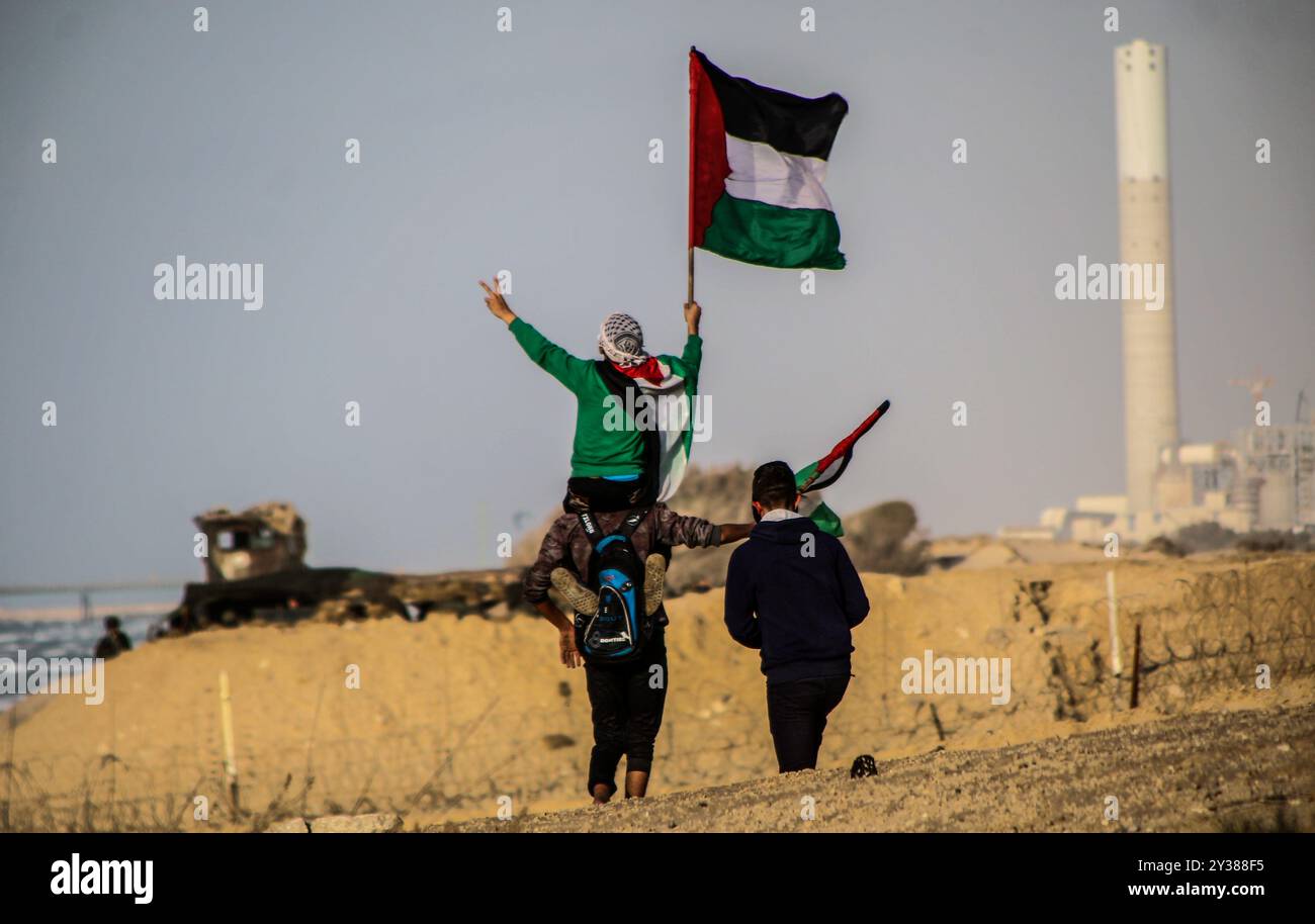 Un certo numero di dimostranti di Gaza sono rimasti feriti durante gli scontri con le forze di sicurezza israeliane sulla costa vicino a Beit Lahia, nel nord di Gaza, il 17 dicembre 2018, durante la 20a manifestazione navale settimanale. I manifestanti palestinesi hanno lanciato pietre usando fionde, mentre le truppe israeliane hanno usato munizioni di gomma e vive e hanno sparato bombole di gas lacrimogeni per disperdere i manifestanti ferendone almeno 20 con colpi di arma da fuoco e inalazione di gas lacrimogeni. Il paramedico della Mezzaluna Rossa, Ahmad Abdel Bari al-Ful, è rimasto ferito al braccio sinistro da un proiettile di gomma sparato dalle truppe israeliane mentre era in servizio durante la protesta. Un flo per la libertà Foto Stock