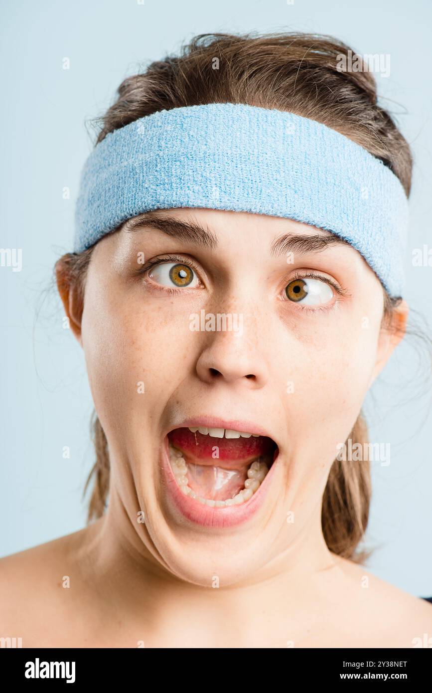 Donna, faccia strana e divertente con fascia, moda retrò e commedia con costume funky in studio. Cappello, occhi incrociati e scherzo con hipster, gesti pazzi Foto Stock