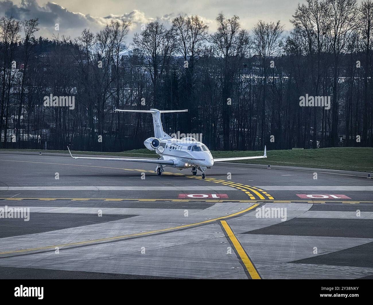 Privatjet, Flughafen, Startbahn, kleiner Jet, Winterlandschaft, grauer Himmel, Luxustransport, Geschäftsreise, Luftverkehr, exklusive Reisen, Runway, Flugzeug am Boden, Vorbereitung auf den Start, Wolkenhimmel, Bäume im Hintergrund, stille Atmosphäre, kaltes Wetter, Luftfahrt, modernes Reisen, Exklusiver Flug, Pilot, Flugvorbereitung, Hangarbereich, eleganter Jet, Business Aviation, winterliche Stimmung, private Flugreisen, Luftfahrtindustrie, Reisemobilität, Komfortreise, Flugsicherheit. Symbolfoto *** Jet privato, aeroporto, pista, piccolo jet, paesaggio invernale, gray sky, trasporto di lusso, Foto Stock