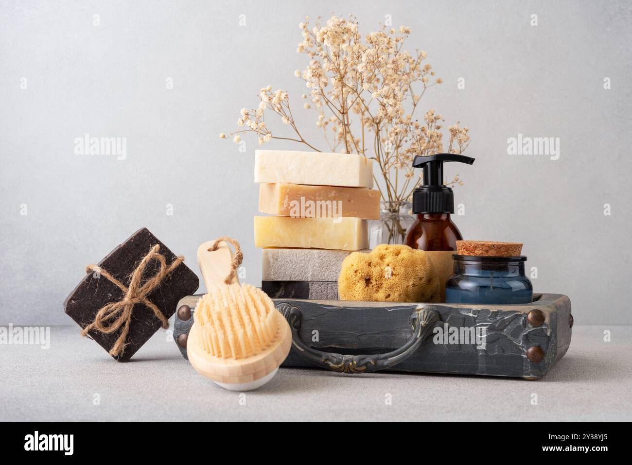 Un set da bagno splendidamente arredato con saponi fatti a mano, una spazzola posteriore in legno e una spugna naturale. Ideale per la cura della pelle naturale e per le routine di benessere Foto Stock