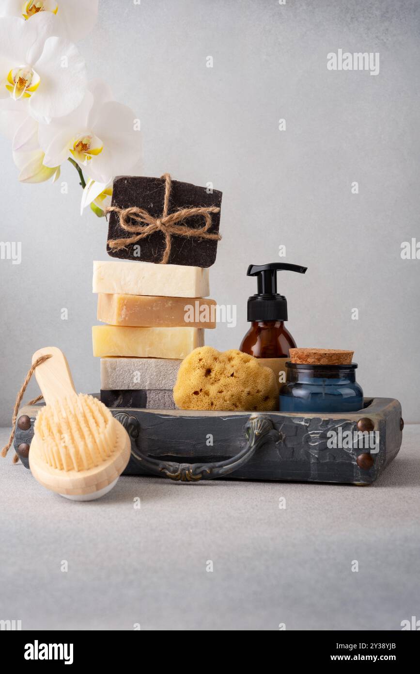 Un set da bagno splendidamente arredato con saponi fatti a mano, una spazzola posteriore in legno e una spugna naturale. Ideale per la cura della pelle naturale e per le routine di benessere Foto Stock