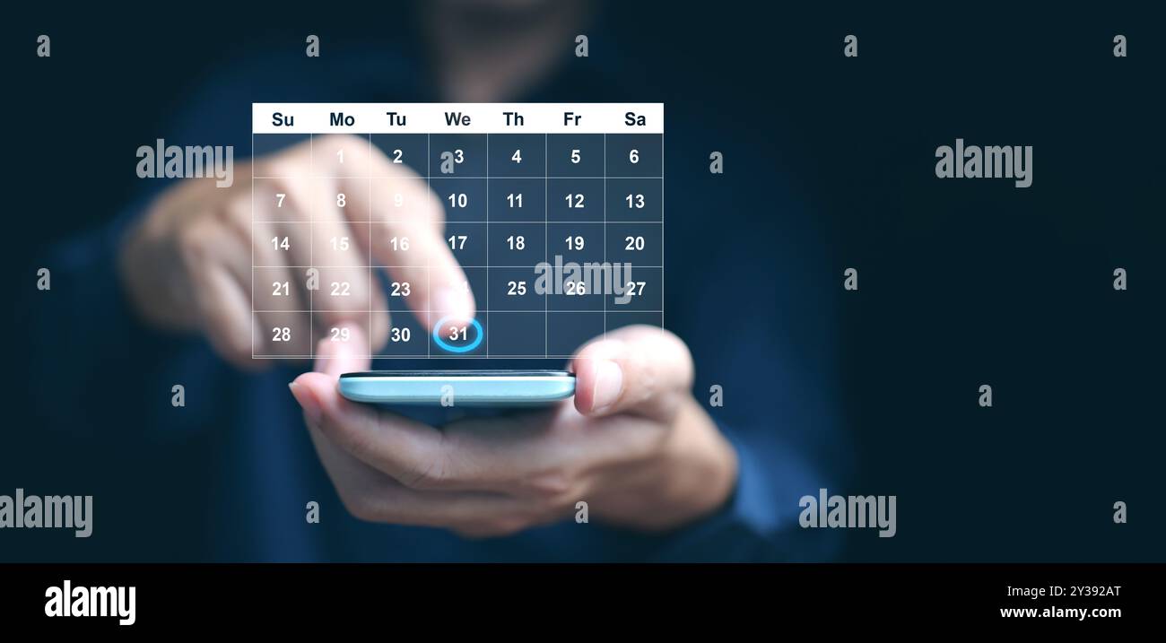 Concetto di pianificazione e gestione del tempo. Un uomo gestisce il proprio tempo utilizzando un'interfaccia calendario su schermo virtuale sul proprio smartphone Foto Stock