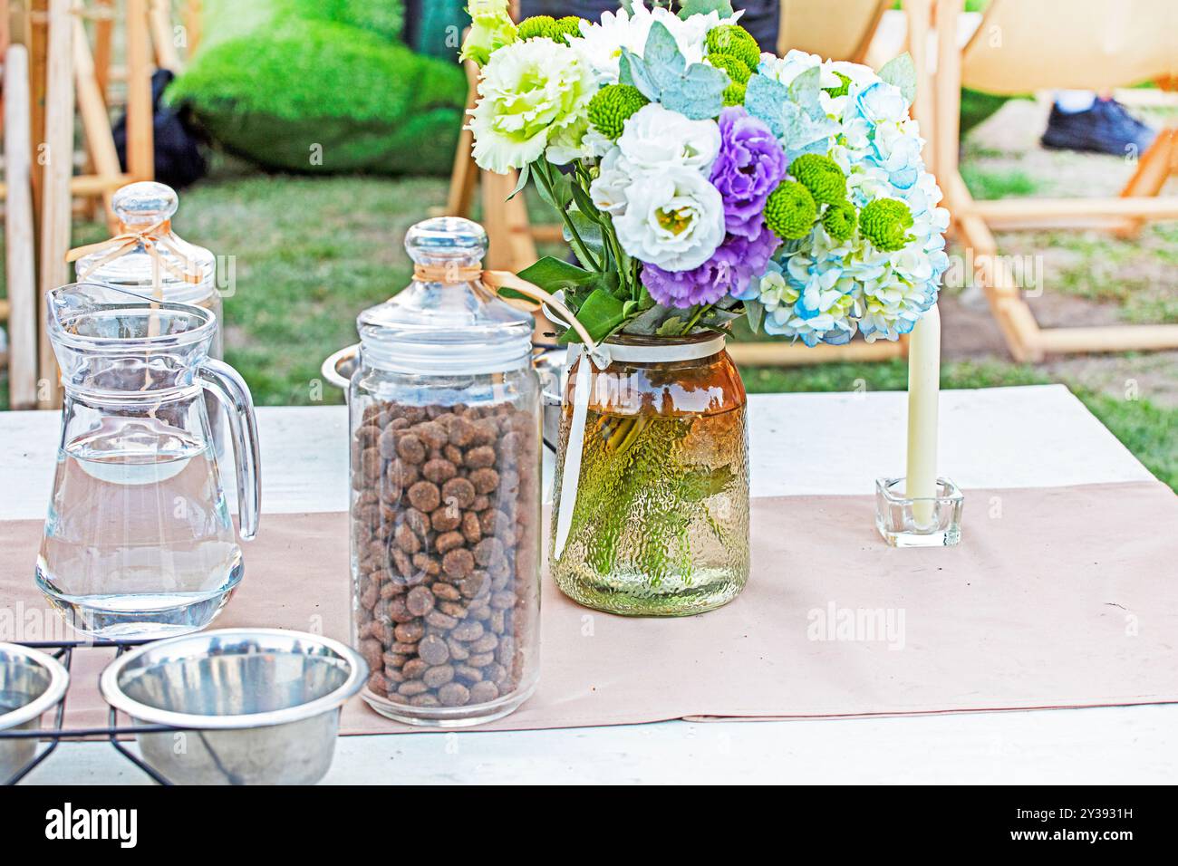 un bellissimo bouquet di fiori freschi sul tavolo accanto al cibo per cani. festa dei cani Foto Stock