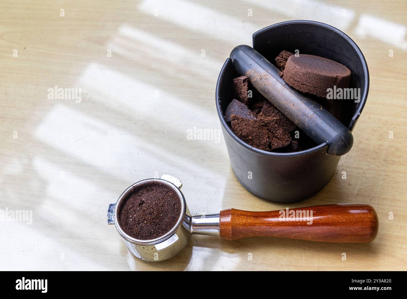 Caffè compattato macinato in scatola con portafiltro accanto. I fondi di caffè sono eccellenti fertilizzanti naturali e organici. Foto Stock