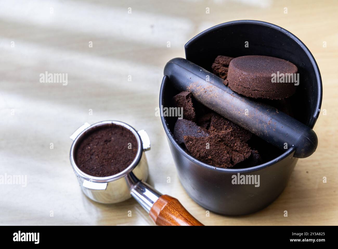 Caffè compattato macinato in scatola con portafiltro accanto. I fondi di caffè sono eccellenti fertilizzanti naturali e organici. Foto Stock