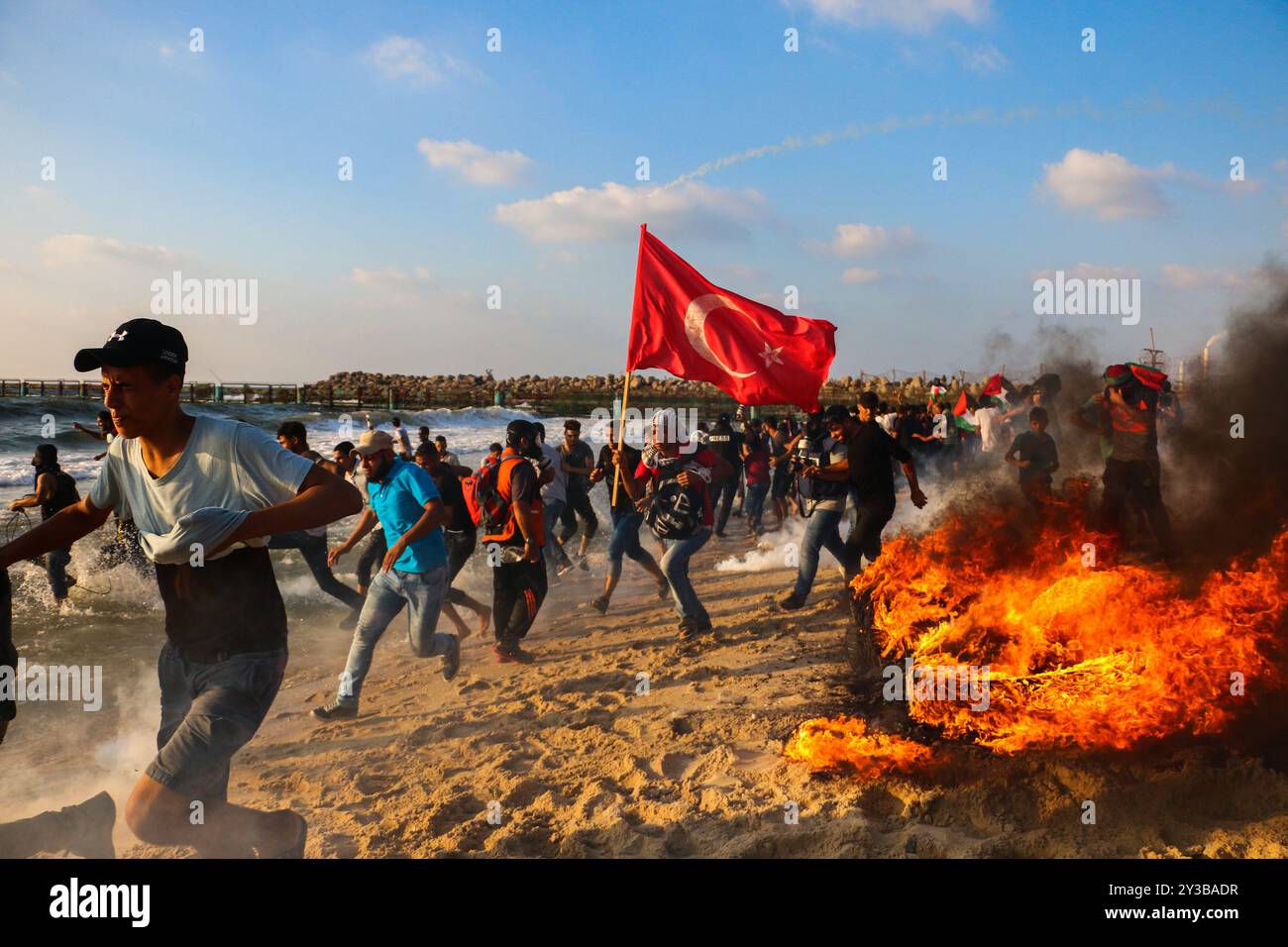10 palestinesi su una flottiglia di dozzine di navi navali lanciate dalla città di Gaza sono stati feriti dal fuoco della marina israeliana dopo essersi avvicinati al confine marittimo al largo della costa di Gaza. Decine di manifestanti palestinesi sono stati feriti anche da colpi di arma da fuoco israeliani e gas lacrimogeni durante una manifestazione sulla costa vicino a Gaza City. L'evento è stato organizzato dall'alta Commissione Nazionale della grande marcia del ritorno e della rottura dell'assedio di Gaza, che è stato tentato di rompere il blocco di undici anni dell'enclave palestinese. La flottiglia partì dal porto di Gaza dirigendosi verso le acque israeliane. Alcuni di Foto Stock
