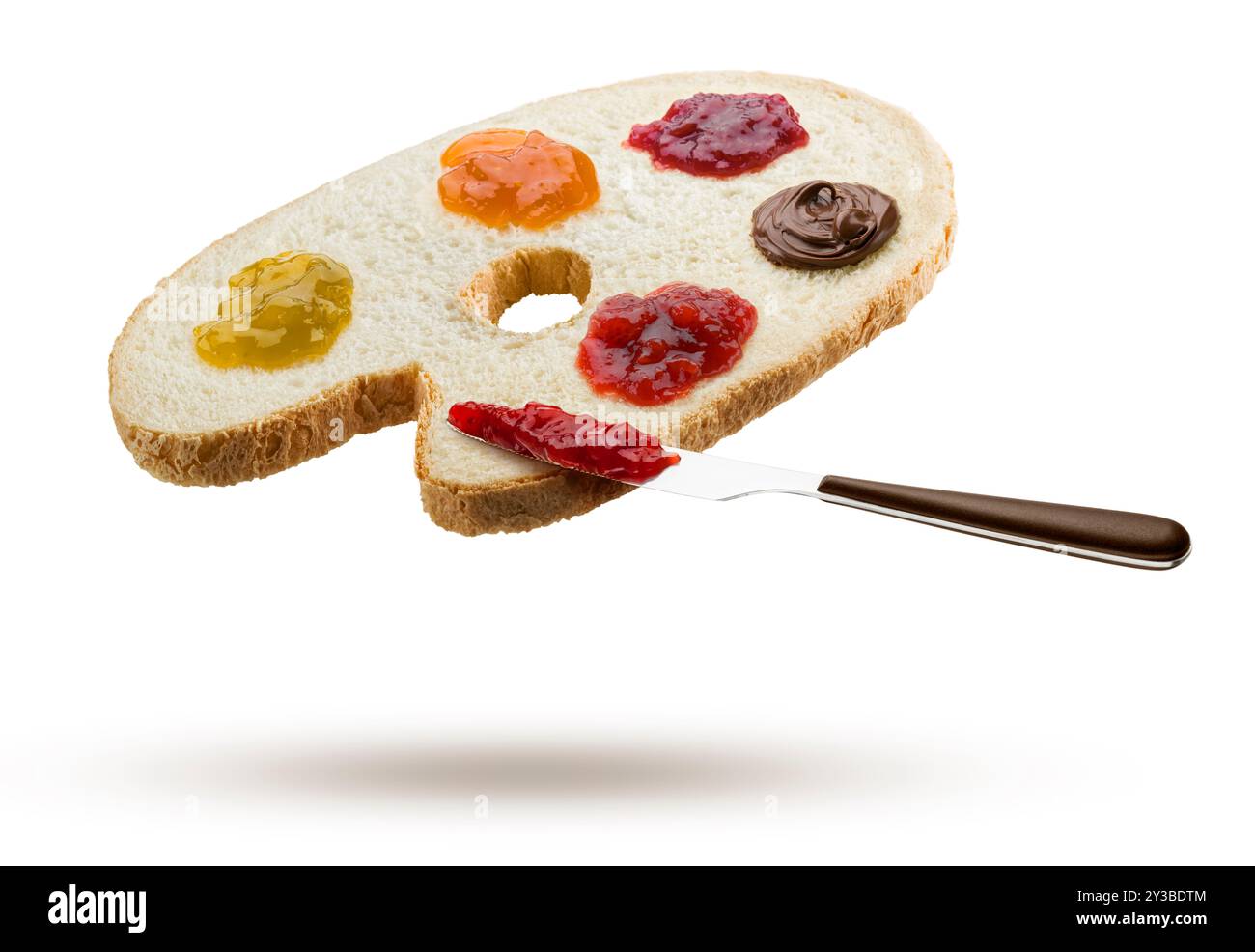 Fetta di pane bianco a forma di tavolozza di un pittore con varietà di marmellate e coltelli che volano su sfondo bianco. Foto Stock