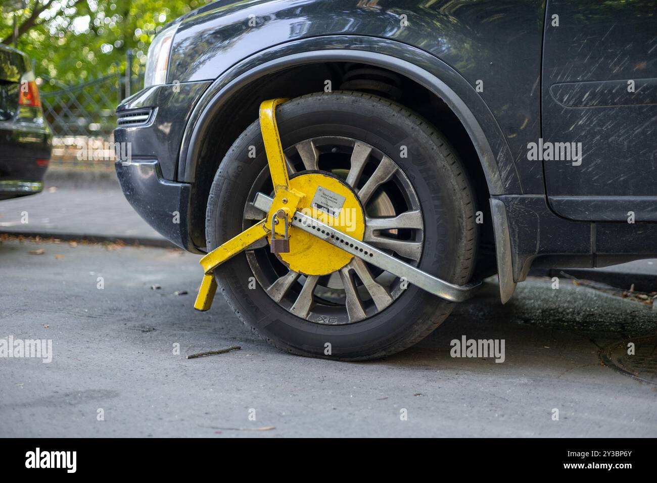 Cracovia, Polonia - 8.09.2024: Veicolo immobilizzato da un morsetto per ruote giallo brillante su una strada della città durante l'autunno Foto Stock