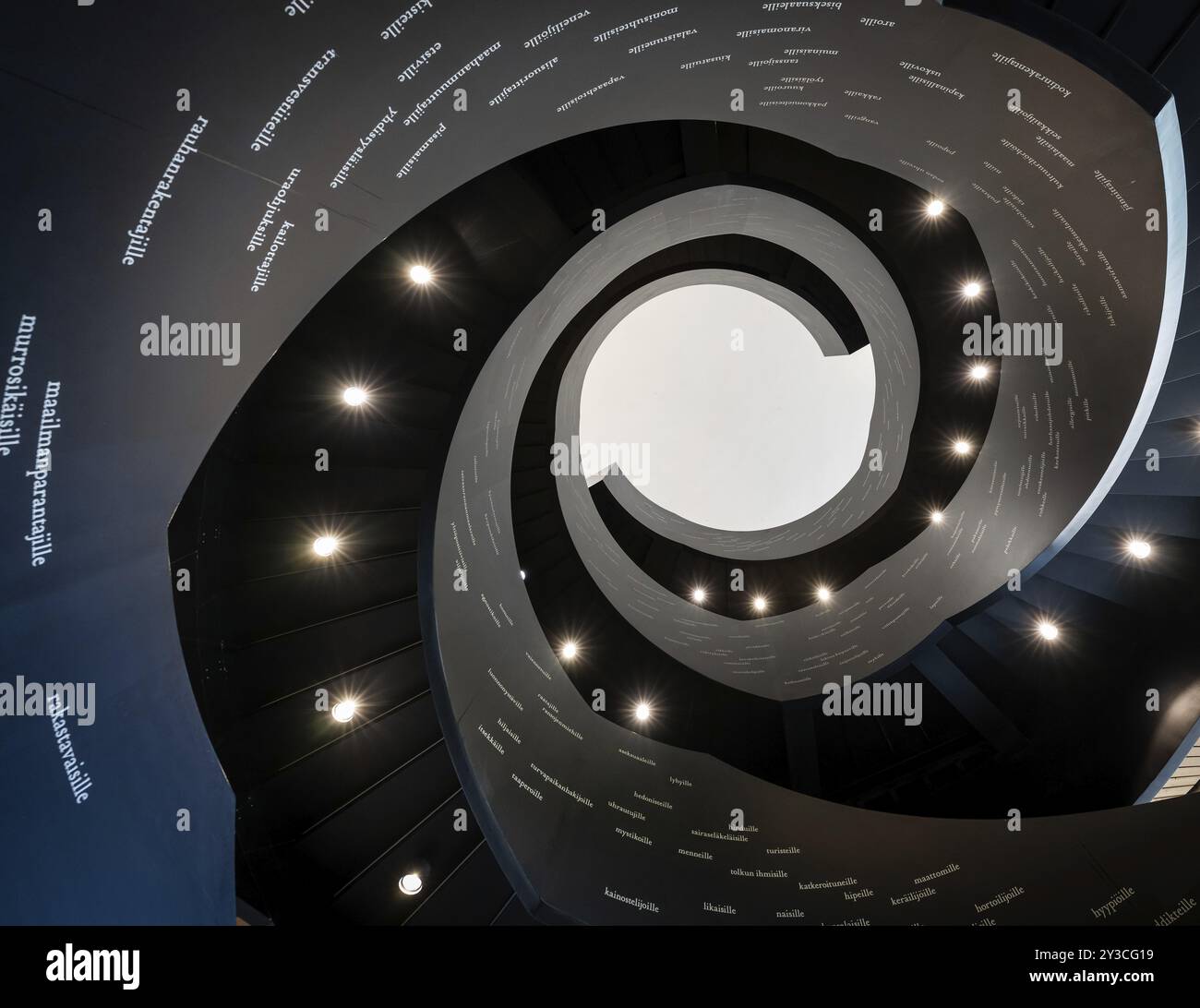Scala a chiocciola stampata con parole finlandesi, Biblioteca centrale e Centro culturale Oodi, progettata da ala Architects, Helsinki, Finlandia, Europa Foto Stock